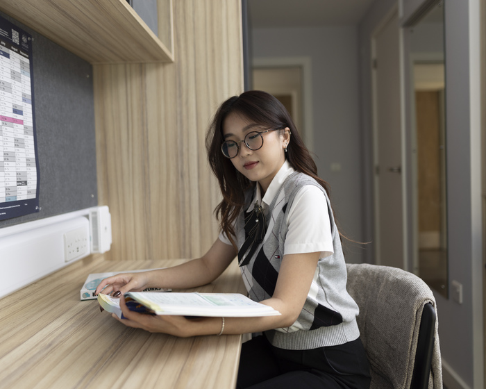 A student reading a book in their accommodation