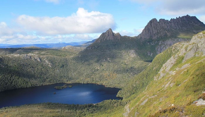 Lake surrounded by small mountains covered in grass