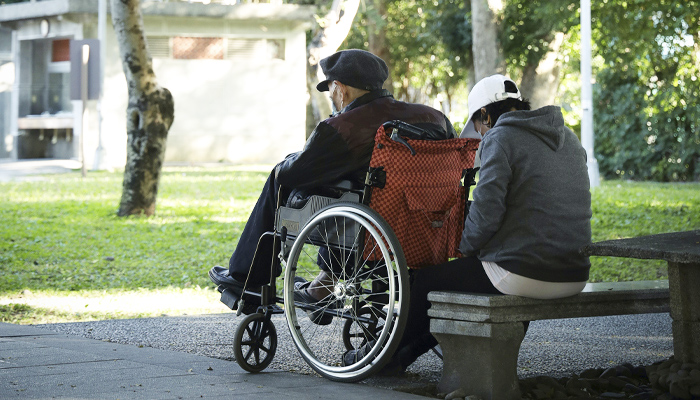 An elderly couple sitting in the park