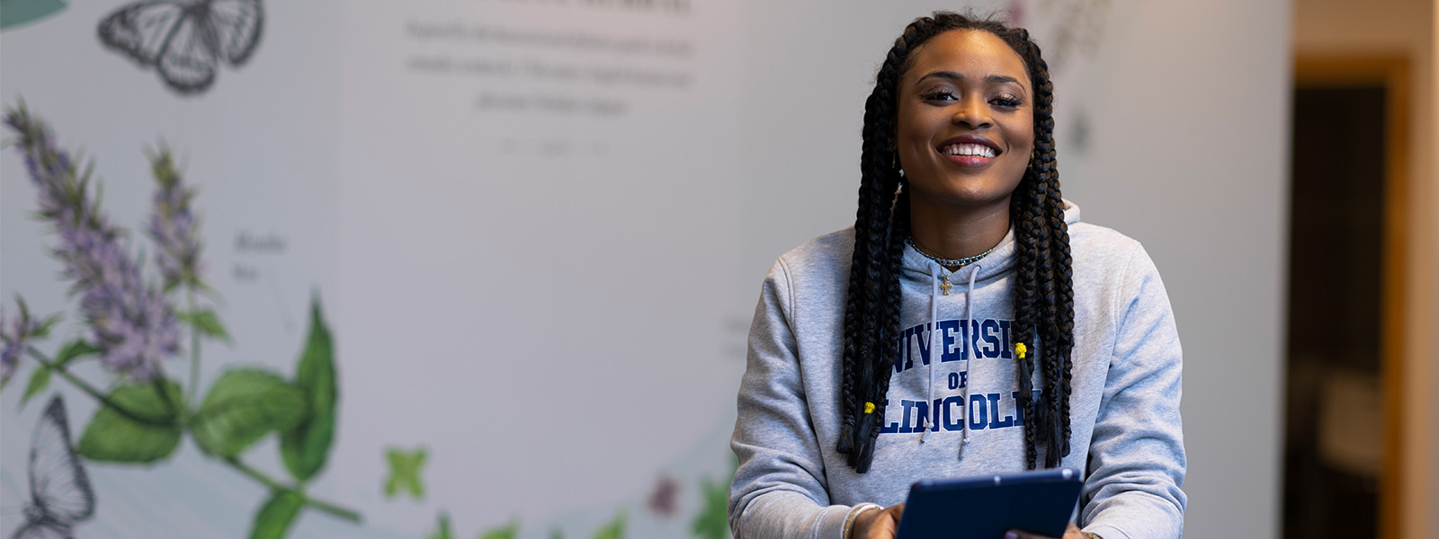 A student smiling with an Ipad