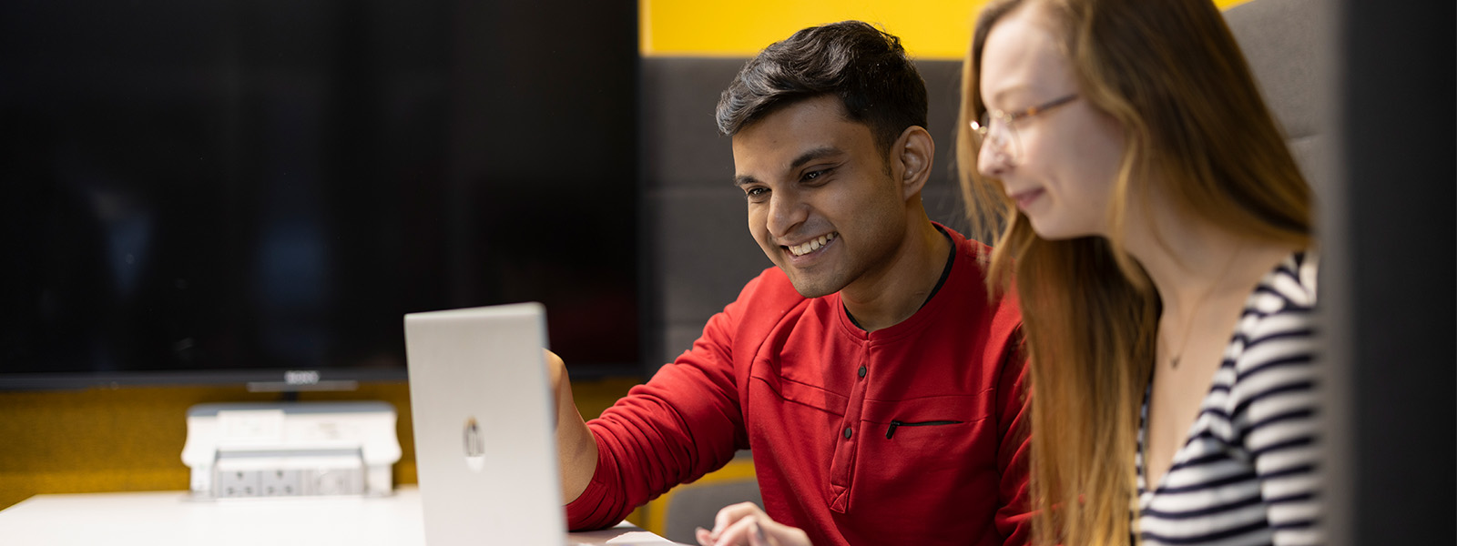 Two students looking at a laptop