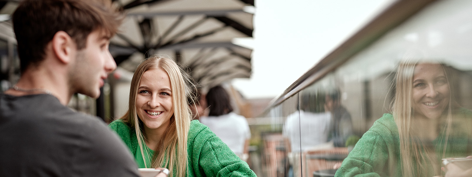 Two students sat at a table outside talking